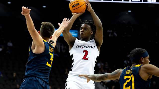 Cincinnati Bearcats guard Jizzle James (2) hits a 3-point basket as West Virginia Mountaineers guard Kerr Kriisa (3) defends in the first half of the Big 12 Conference tournament between Cincinnati Bearcats and West Virginia Mountaineers at T-Mobile Center in Kansas City, Mo., on Tuesday, March 12, 2024.